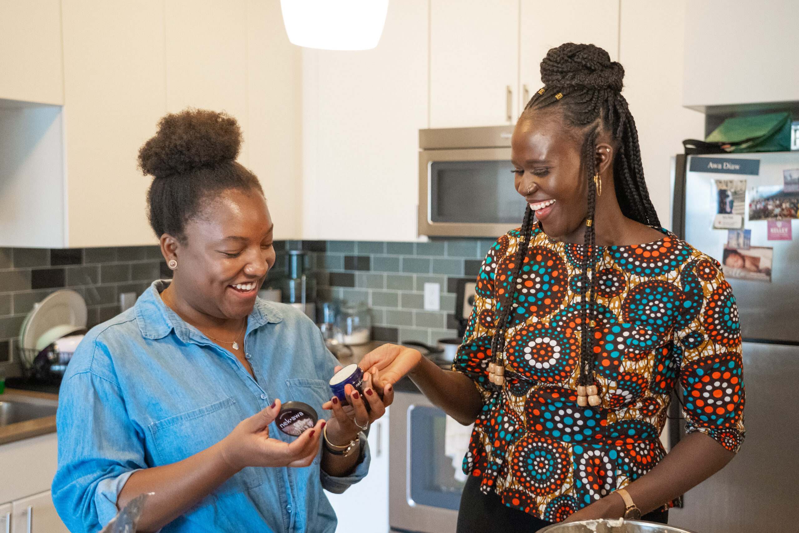 Two women stand smiling