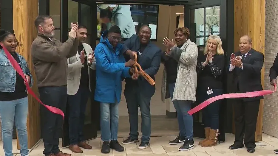 Jamie Hemmings cutting opening day ribbon at store