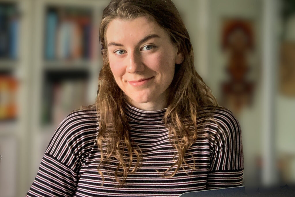 Woman sits in front of an open laptop