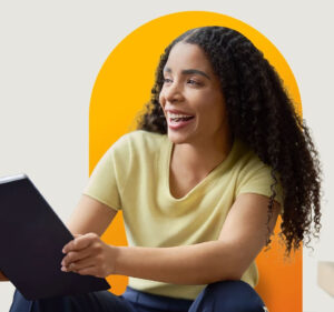 Smiling woman looking up from her laptop computer