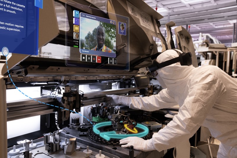 Worker in a semiconductor factory, wearing a white clean room suit and interacting with mixed reality