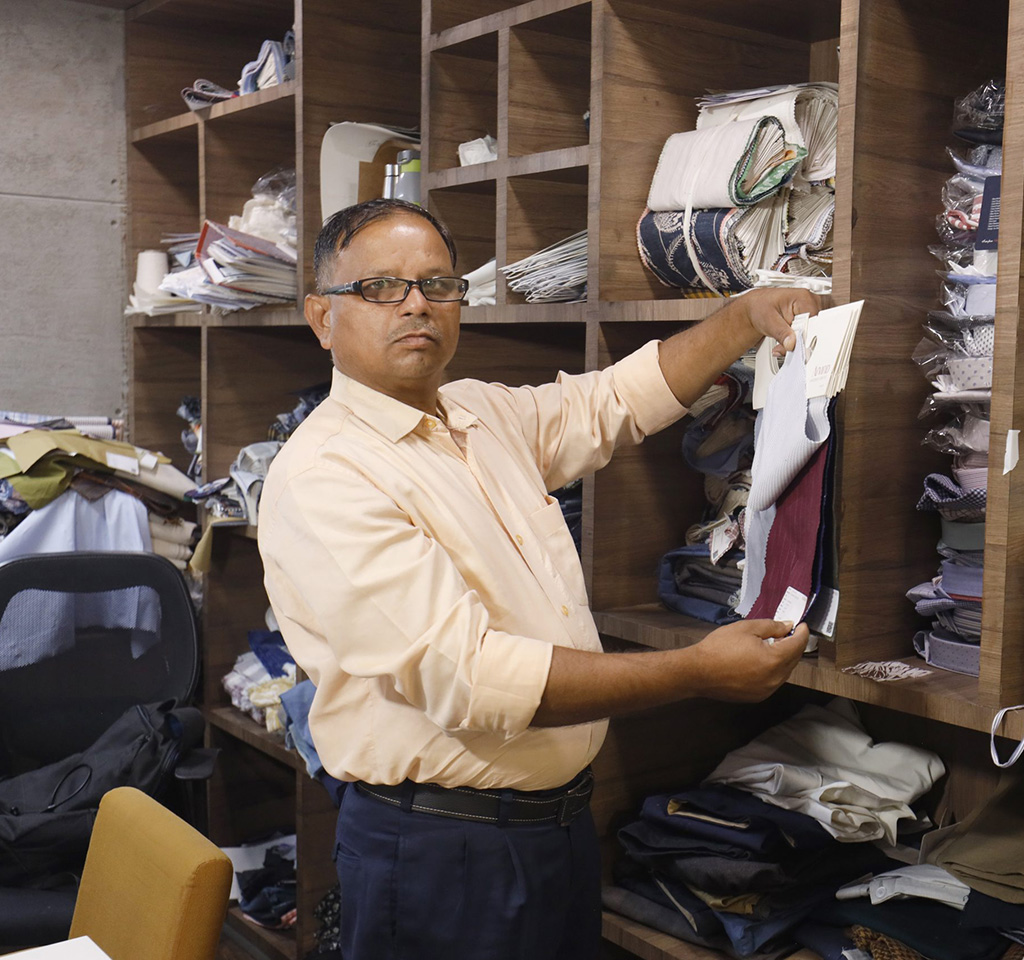 Man inspecting fabric samples in a textile facility in India