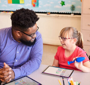 Teacher and a young student sitting in a classroom