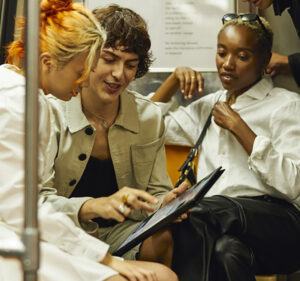 Three people discussing what's on the screen of a tablet device