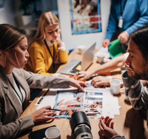 Four people sitting around a table inspecting photos