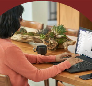 Woman sitting at a table with a cup of coffee and a laptop computer