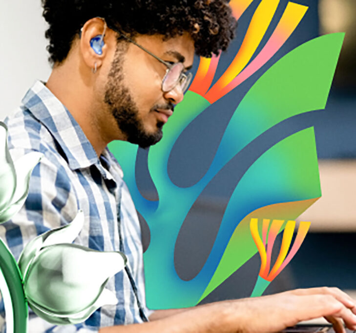 Man wearing earbuds while working on a laptop computer