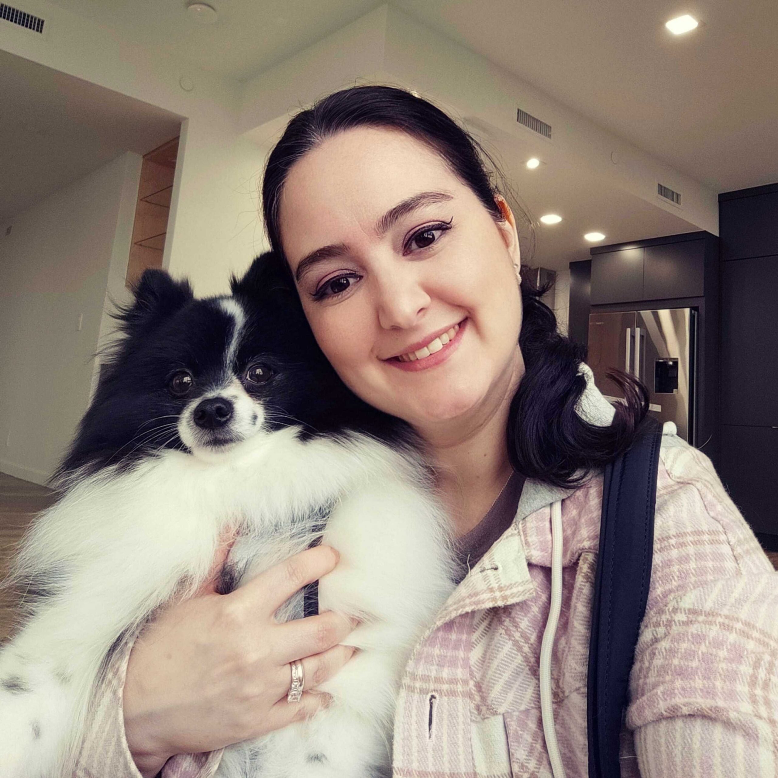 Woman holding a dog smiling at the camera