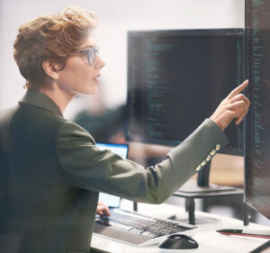 Woman in a business suit interacting with a large touchscreen