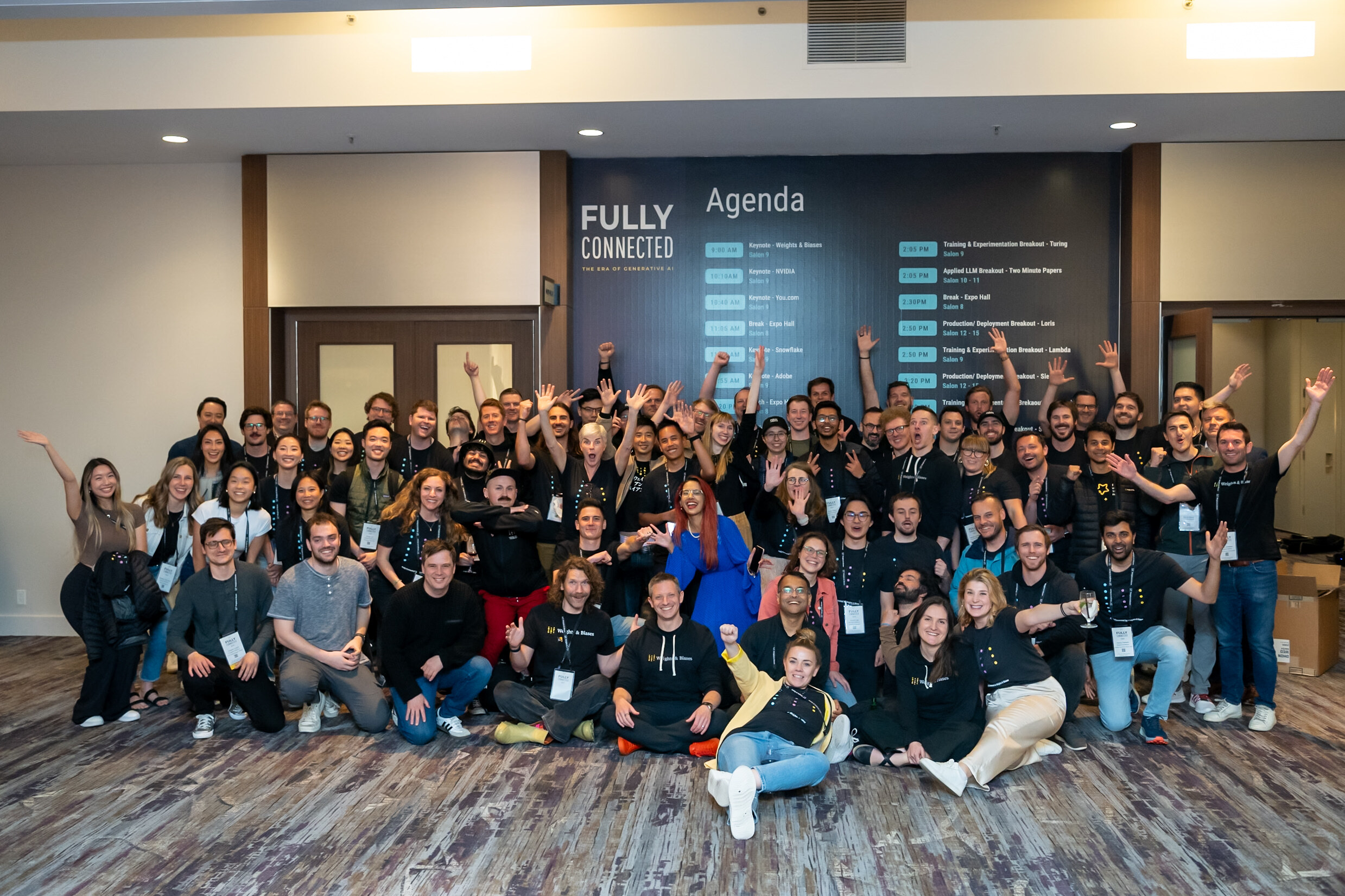 Photo of a group of employees from Weights & Biases company gathered in a room at a conference. 