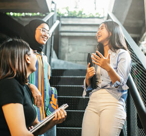 Three young women talking on a stairwell