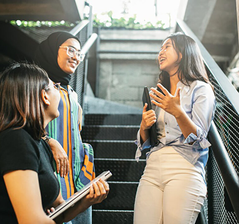 Three young women talking on a stairwell