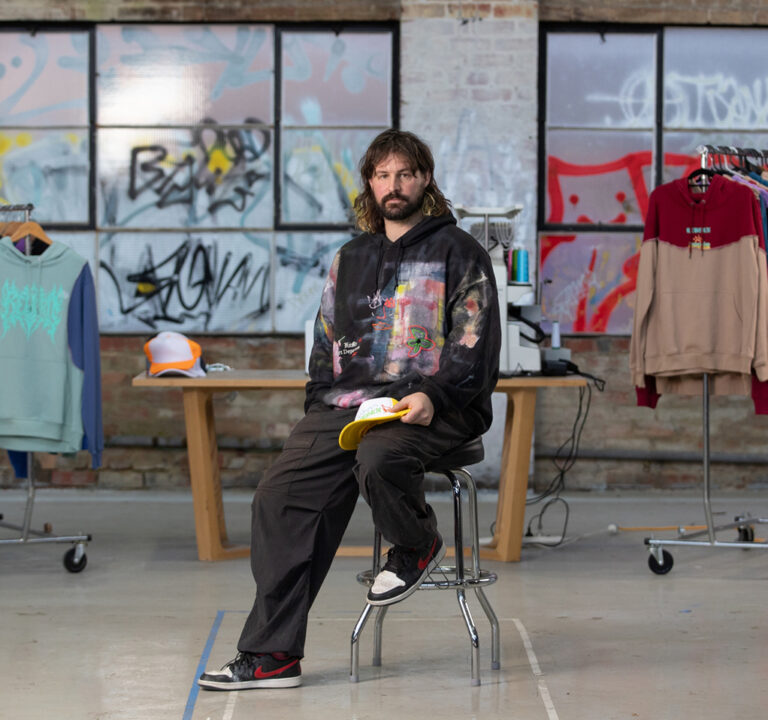 Man seated on a stool in a clothes designer shop