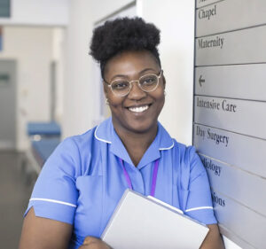 A nurse smiling inside a medical facility