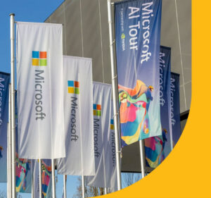 Vertical flags reading Microsoft AI Tour displayed outdoors