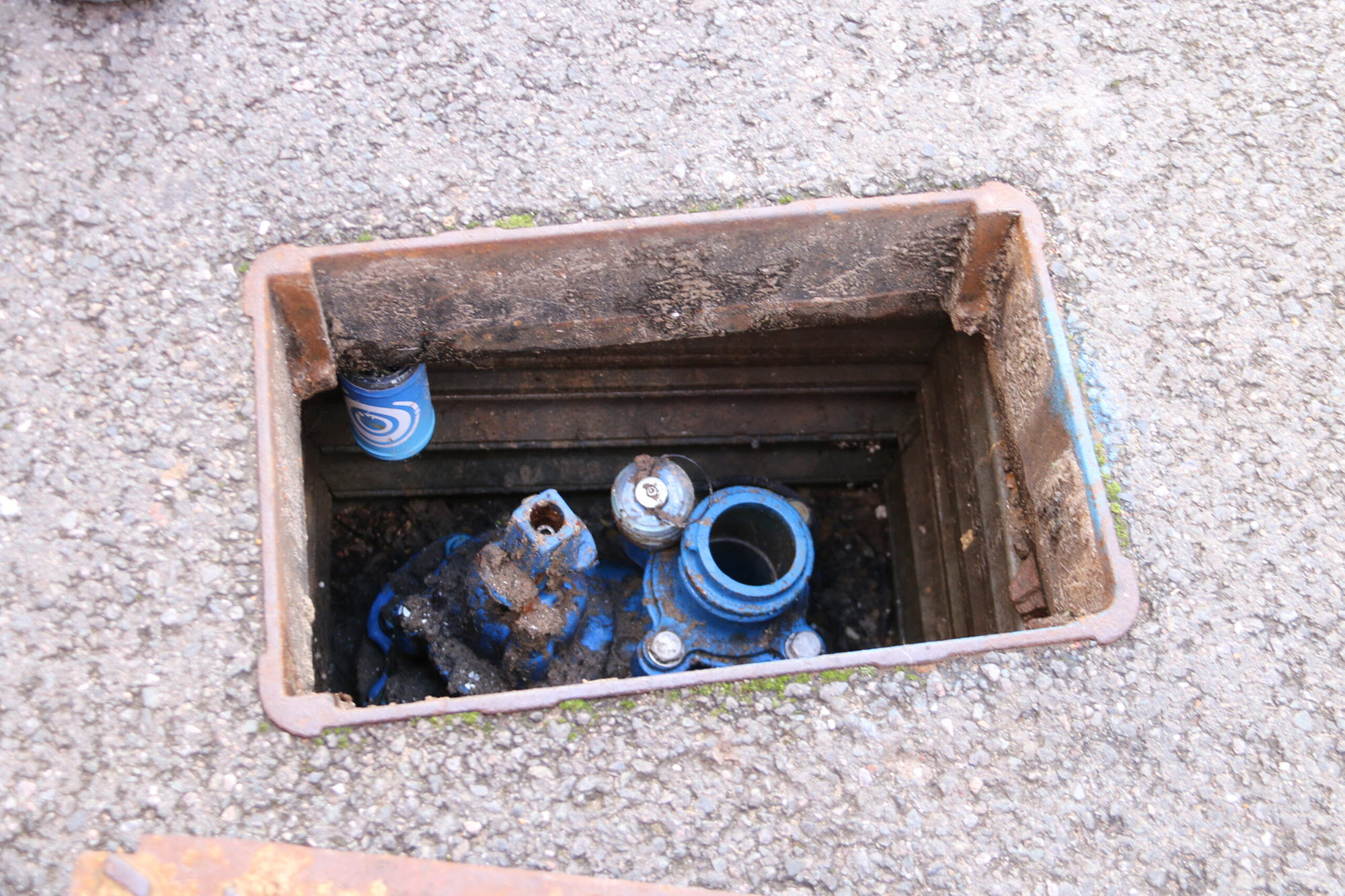 An opening in the sidewalk reveals water pipes, with sensors attached.