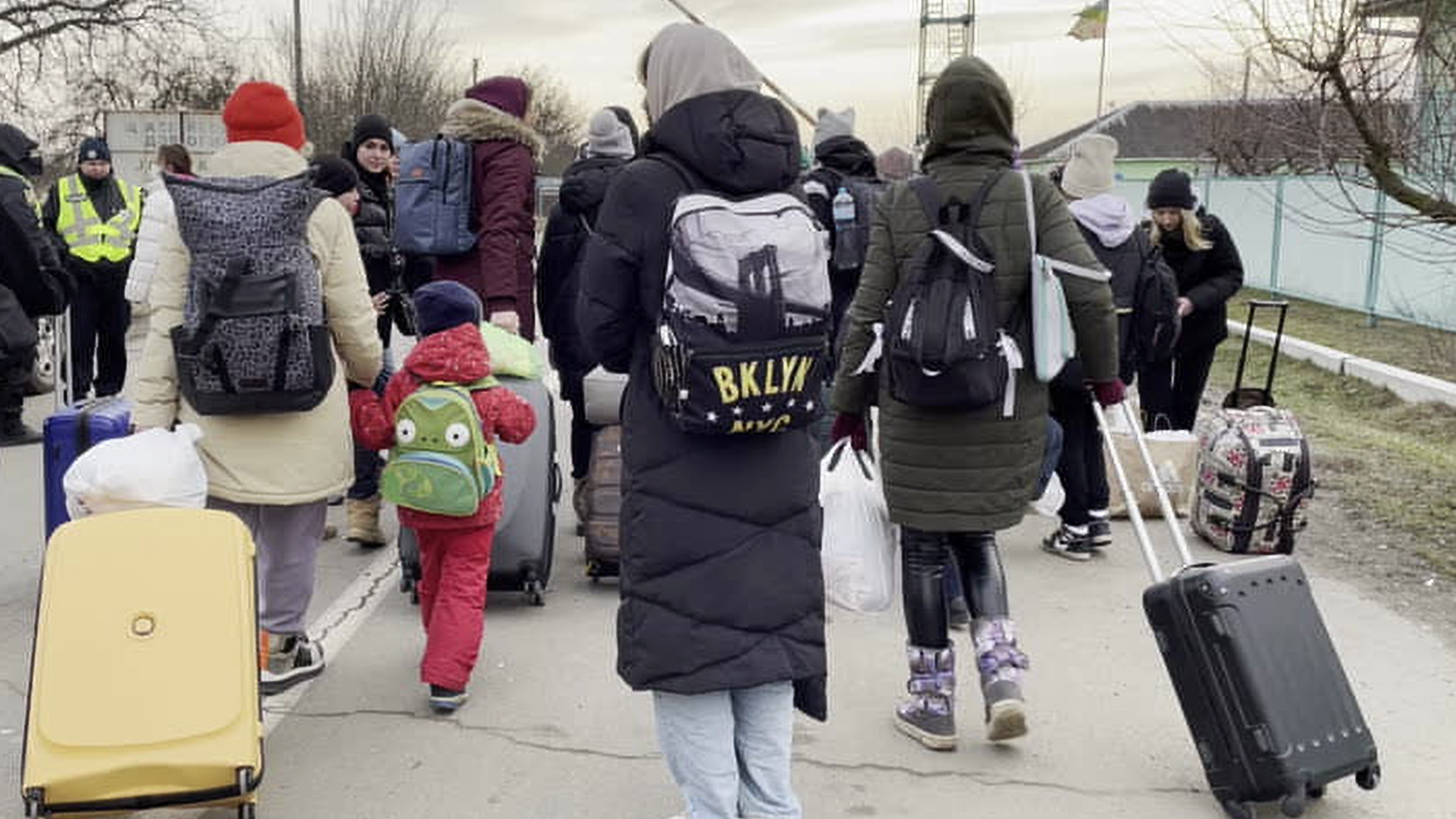 Group of people with backpacks and suitcases evacuating