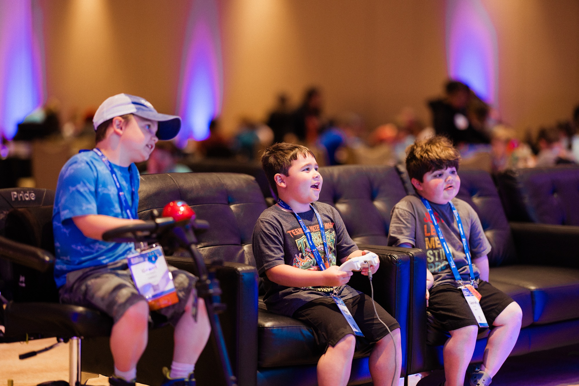 Three boys sitting playing video games using controllers