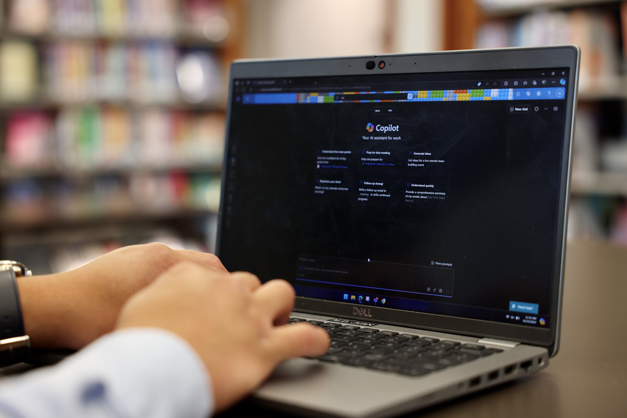 Closeup of person typing on laptop with Copilot interface on screen. 