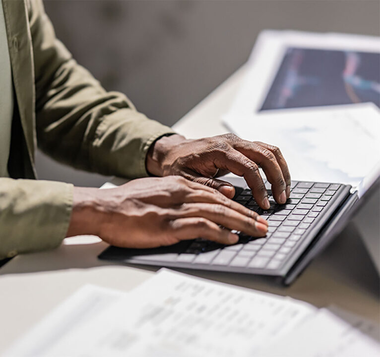 A pair of hands typing at a keyboard