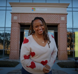 Woman smiling in front of an entrance to a Microsoft building