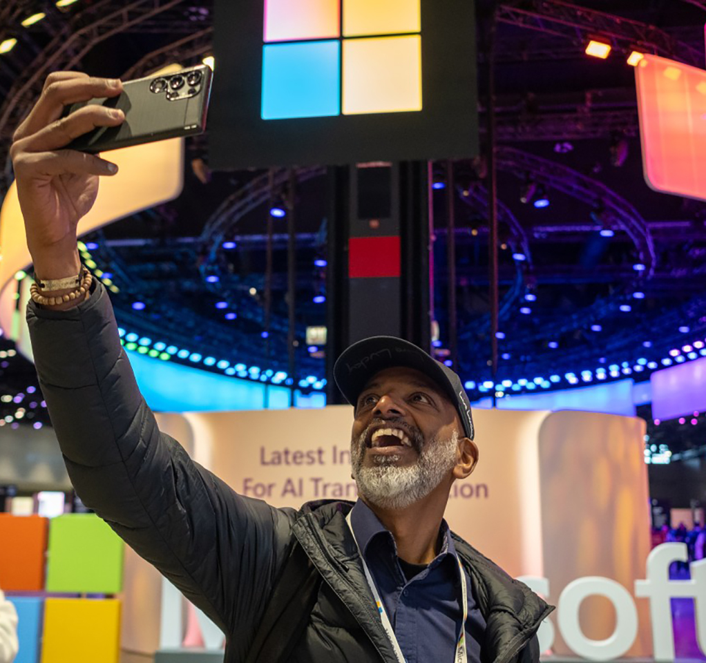 Man taking a selfie on the show floor of a Microsoft event