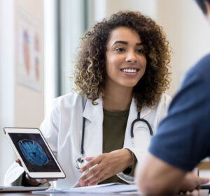 Doctor shares a brain scan image on a tablet screen with a patient