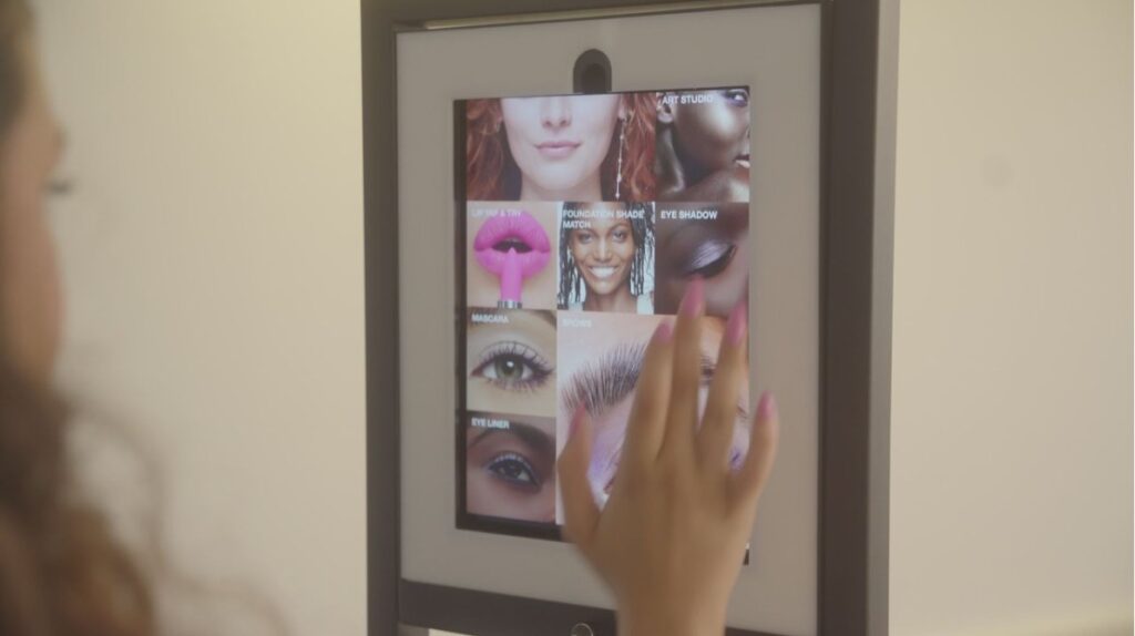 A touch screen showing Estée Lauder's virtual try-on app.