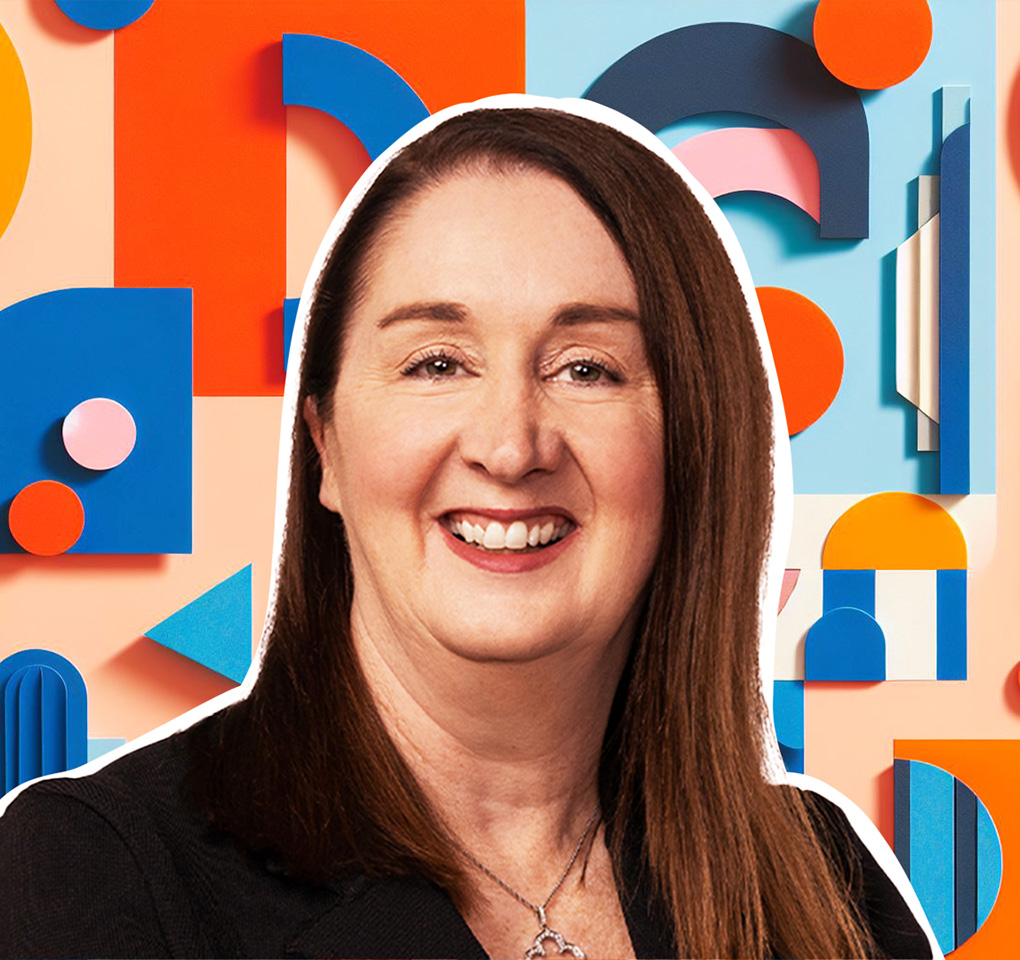 Woman smiling in front of a backdrop of colorful shapes