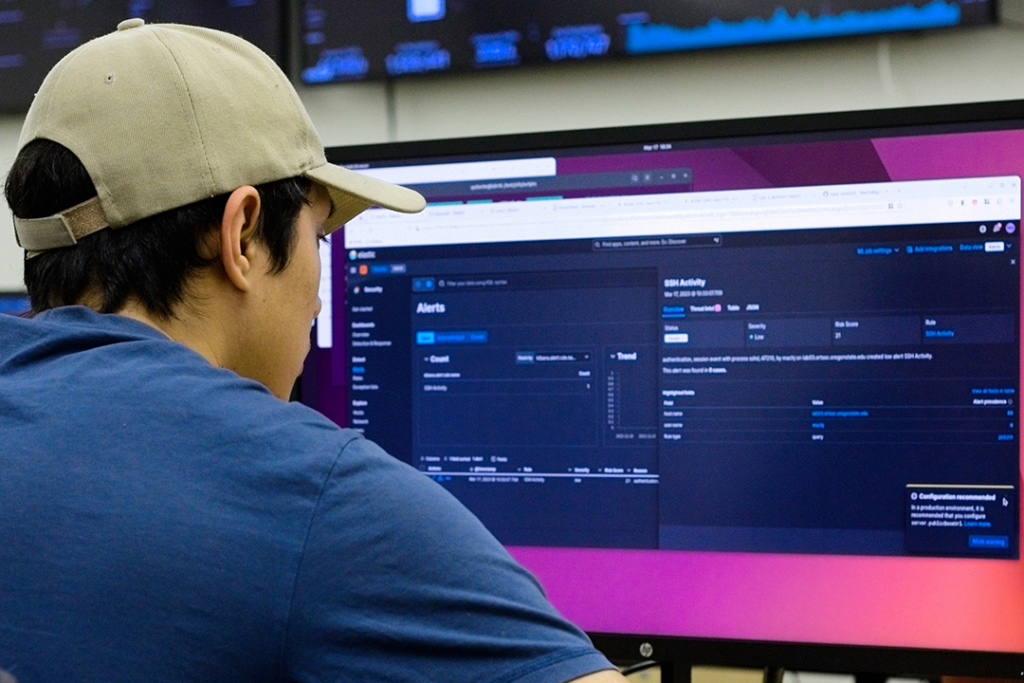 Student working in front of a large computer monitor at Oregon State University's security operations center.